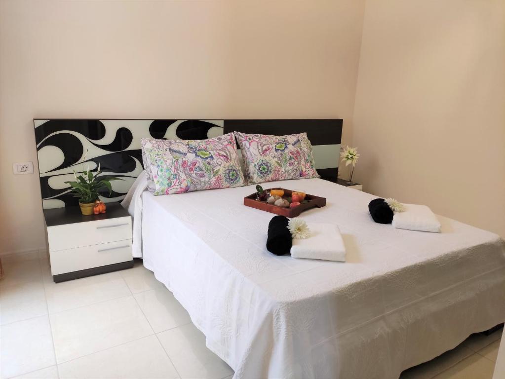 a large white bed with a tray of fruit on it at Casa Confort in Los Abrigos