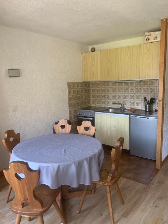 cocina con mesa y sillas en una habitación en Appartement dans résidence avec piscine en Saint-Jean-dʼAulps