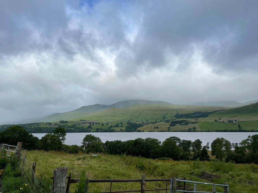 a view of a lake with hills in the background at Century Old Shepherds Cottage overlooking Loch Tay in Aberfeldy