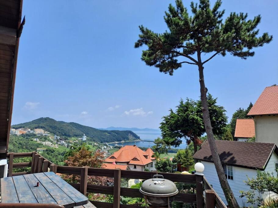 - une vue depuis le balcon d'une maison avec un arbre dans l'établissement Namhae German Village Johannes, à Namhae