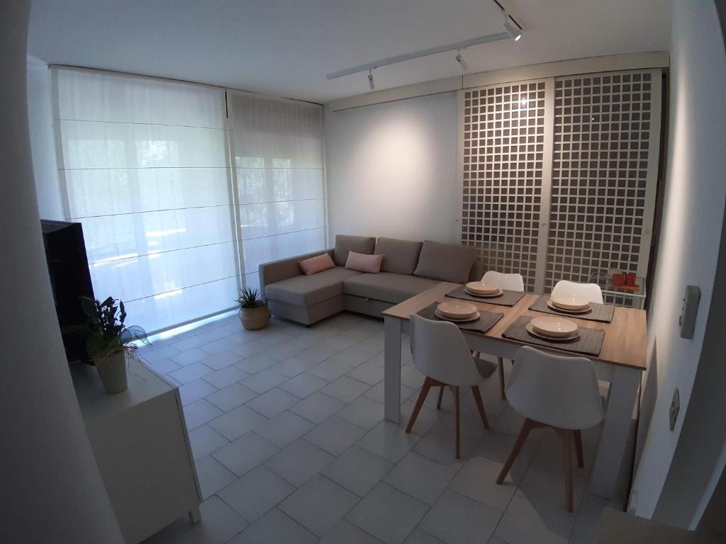 een woonkamer met een tafel en een bank bij Bonaria Apartment in Cagliari