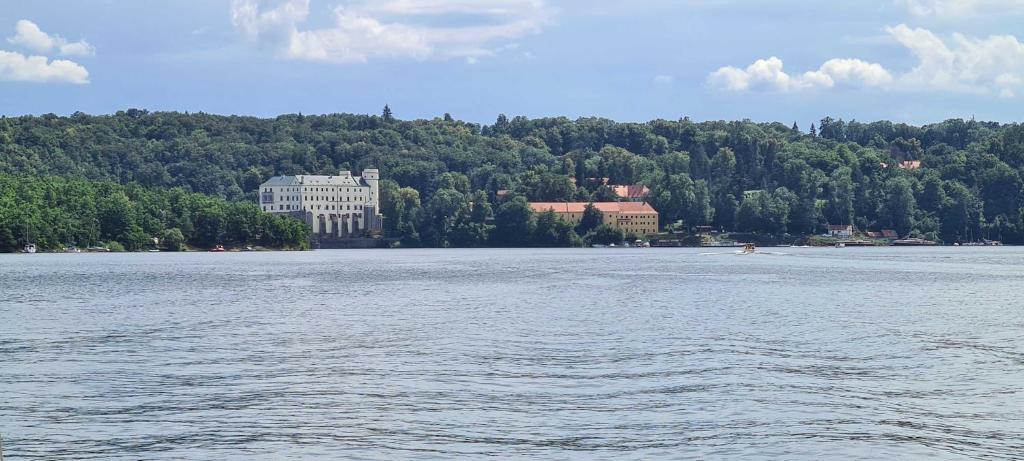 a large building on the shore of a large lake at Orlická přehrada Chata Malá in Kožlí u Orlíka