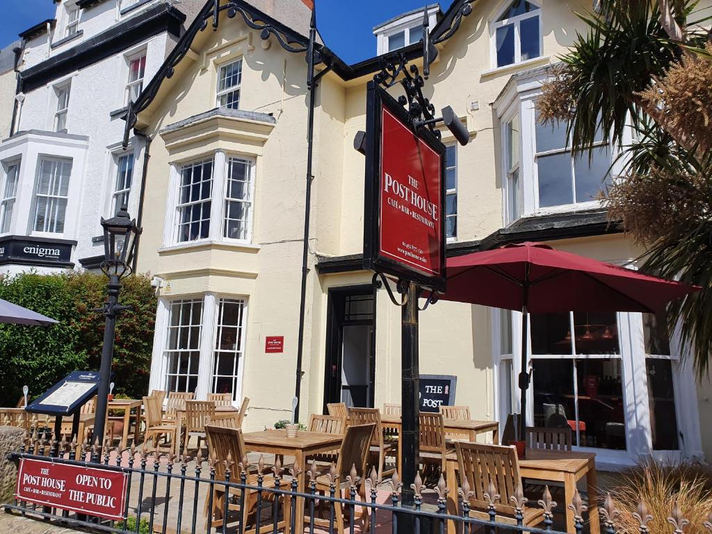 um restaurante com mesas e cadeiras em frente a um edifício em The Post House, Llandudno em Llandudno