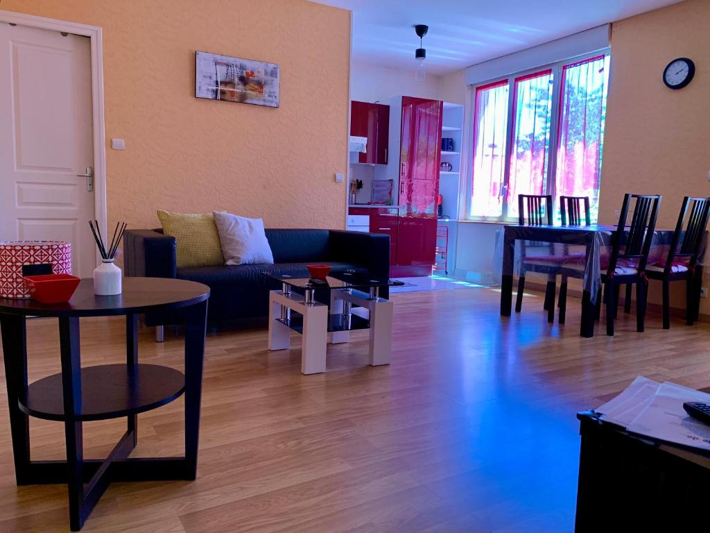 a living room with a couch and tables and a kitchen at RESIDENCE ROKIA - Au fil de l*eau in Royat