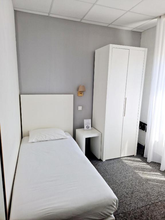 a bedroom with a bed and a cabinet at Hôtel P.L.M. in Cannes