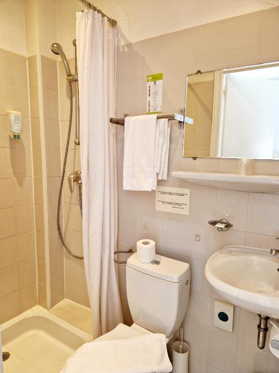 a bathroom with a shower and a toilet and a sink at Hôtel P.L.M. in Cannes
