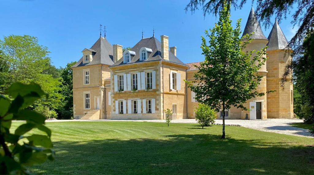 a large house with a grass yard in front of it at Château Bois-Martin in Léognan