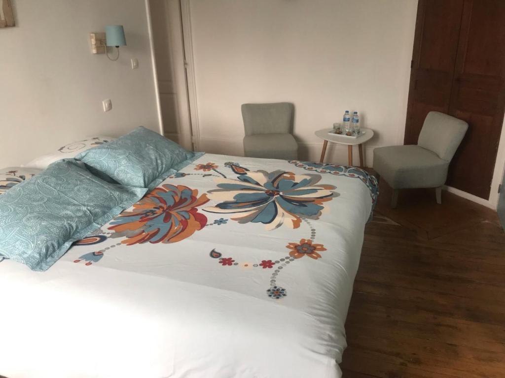 a bedroom with a bed with a flower pattern on it at Chambre Chez L'HABITANT en Centre Ville in Pont-Audemer