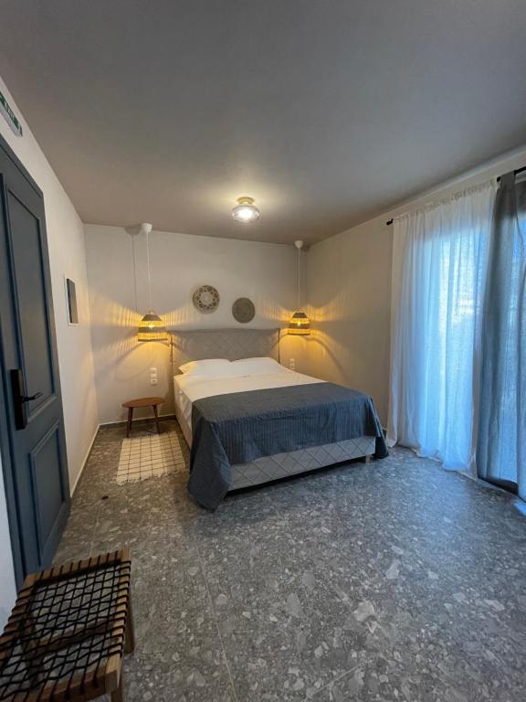 a bedroom with a bed and a window with curtains at Istoria Boutique Hotel in Lefkada Town
