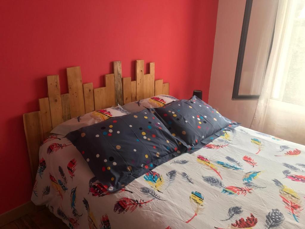 een bed met een houten hoofdeinde in een slaapkamer bij CHAMBRE La Petite VENISE in Pont-Audemer