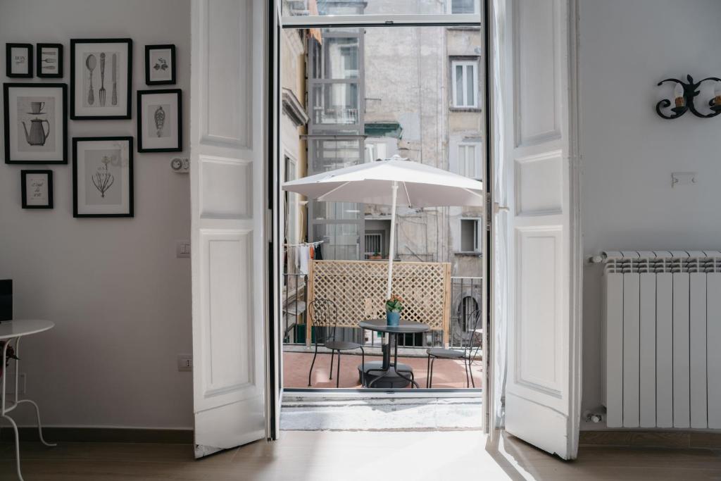 uma porta aberta para um pátio com um guarda-chuva em Casa Napoletana - Nilo em Nápoles