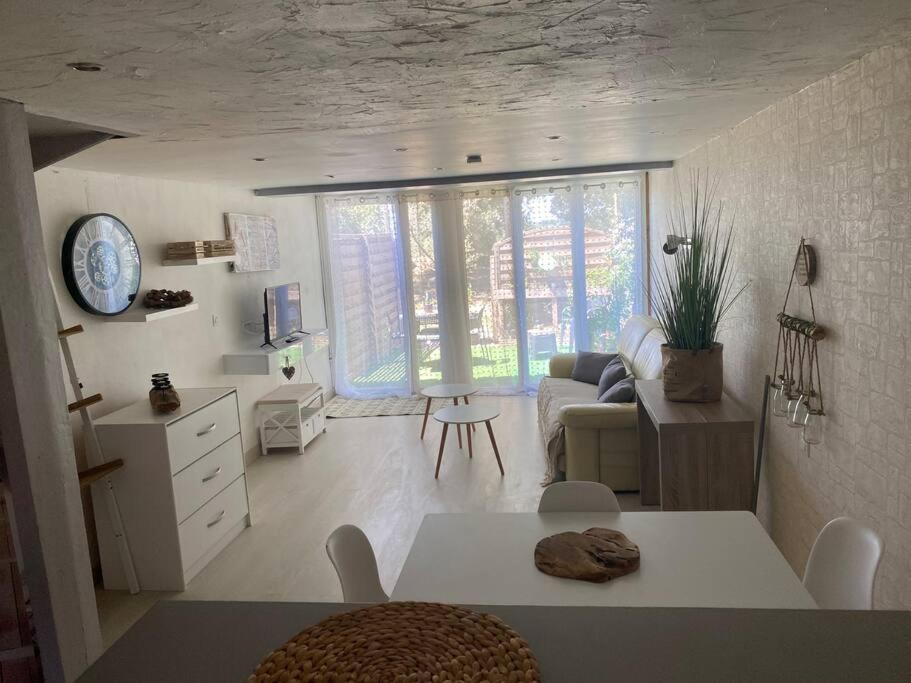 salon z kanapą i stołem w pokoju w obiekcie Un duplex pour 4 personne résidence de vacances w mieście Arles