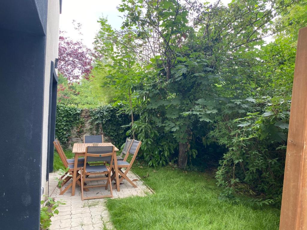 eine Terrasse mit einem Tisch und Stühlen im Garten in der Unterkunft Joli duplex climatisé à 30min Paris in Montmorency