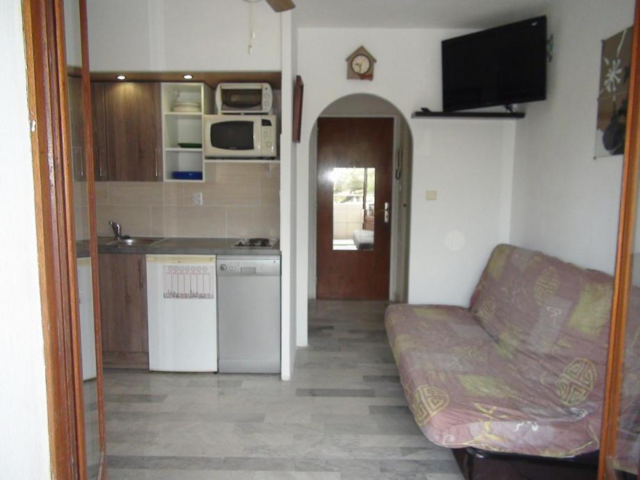 un salon avec un canapé et une cuisine dans l'établissement Vacances au soleil à HYERES 25m2 avec balcon, à Hyères