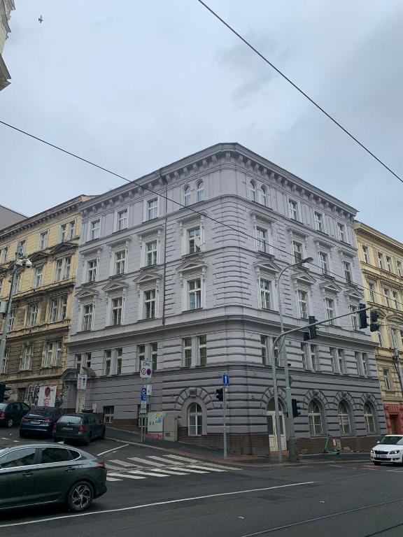duży biały budynek przy ulicy miejskiej z samochodami w obiekcie Luxury Residence Kmochova w Pradze