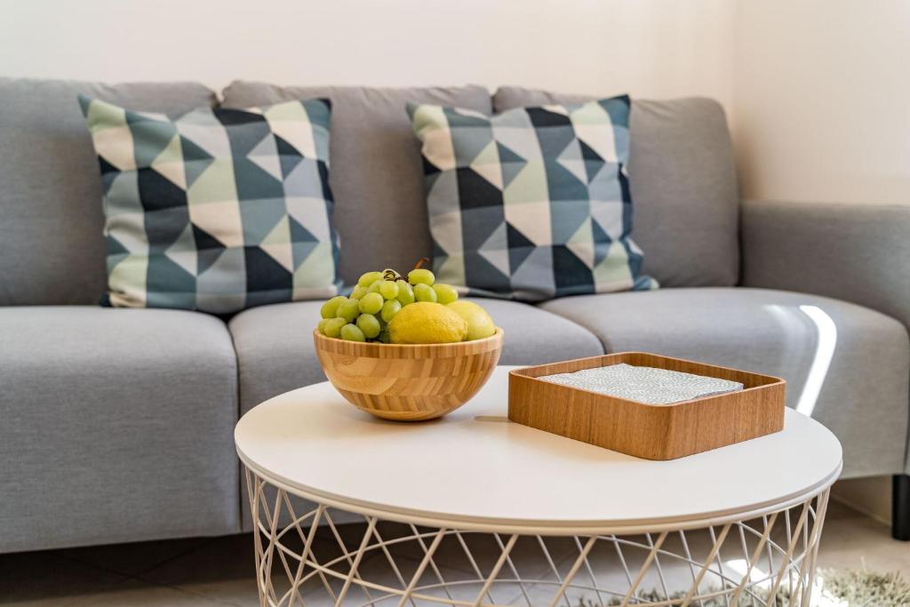 a coffee table with a bowl of fruit on a couch at MOapartment in Cilipi