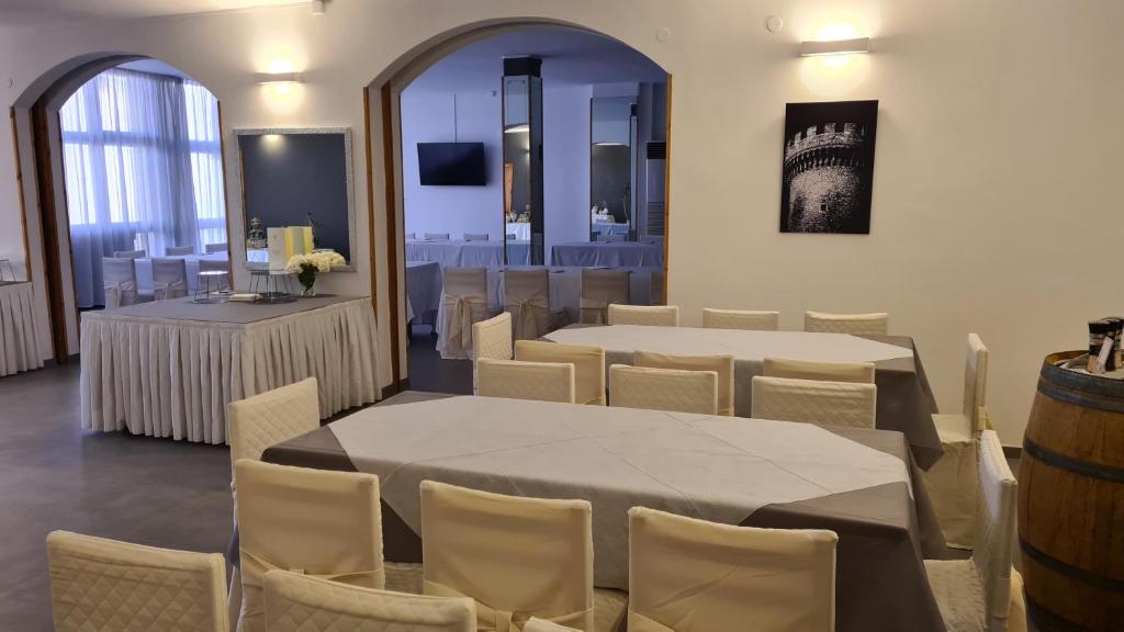 een kamer met tafels en stoelen en een kamer met een vat bij PEDA Hotel Ristorante Pizzeria in Colletorto
