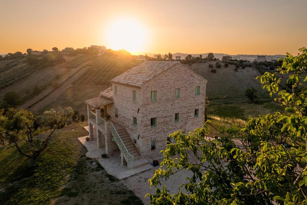 an aerial view of a stone building with the sun in the background at Il casale dei nonni in Grottazzolina