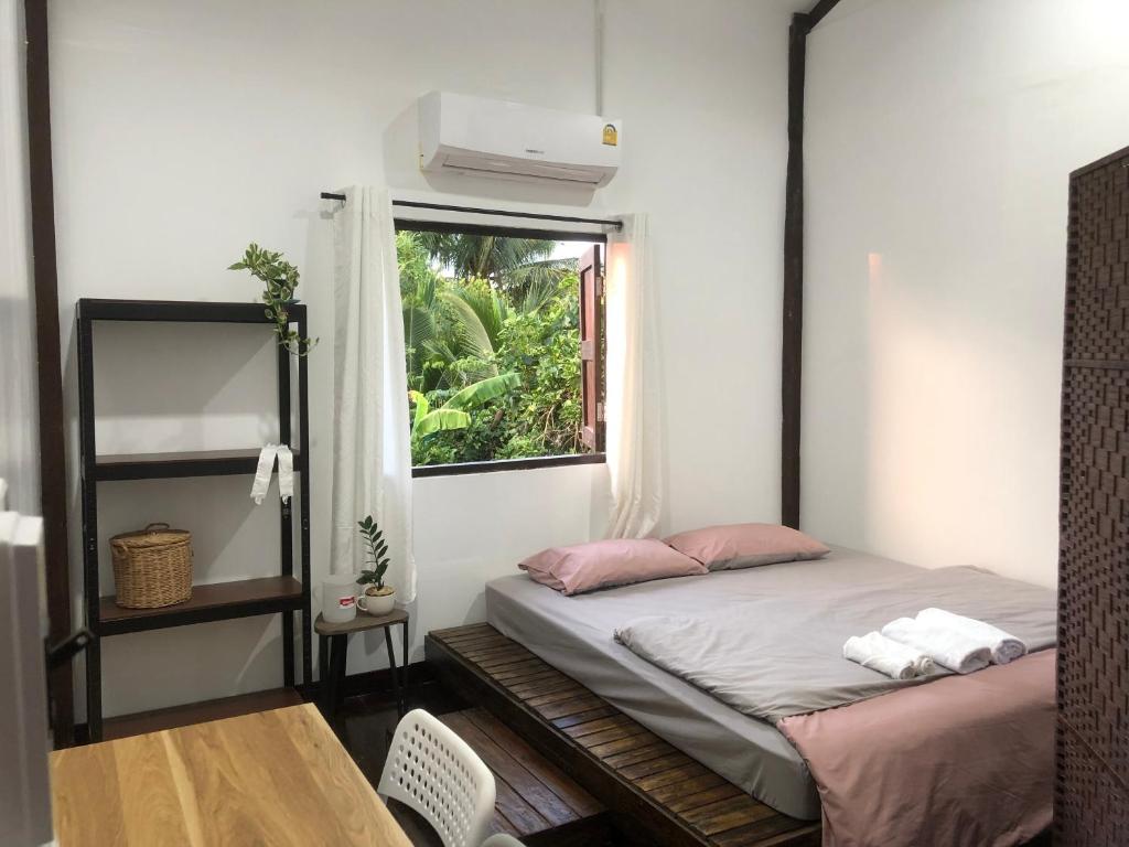 a small room with a bed and a window at Bo Cabin in Garden โบคาบิน อิน การ์เดน in Ban Nong Ki