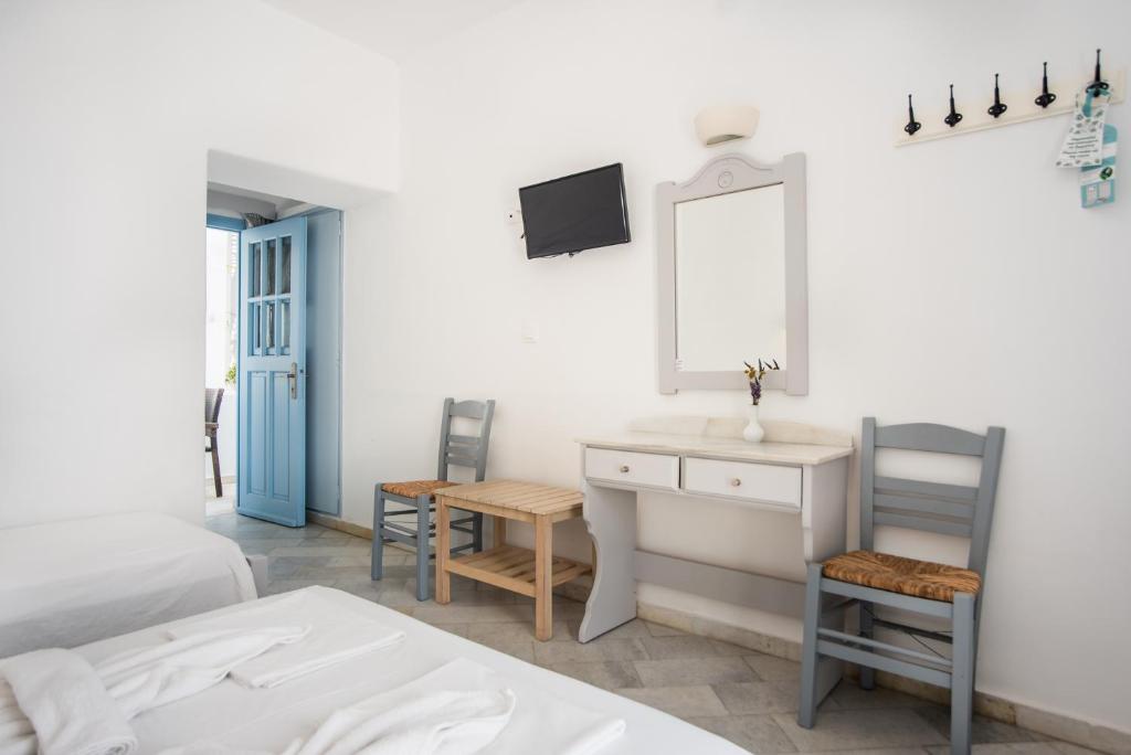 a bedroom with a sink and a desk and two chairs at Hotel Mantalena in Antiparos Town
