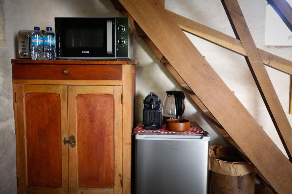 a microwave on top of a refrigerator in a attic at Studio indépendant ,Manoir de la Vove,Perche in Corbon