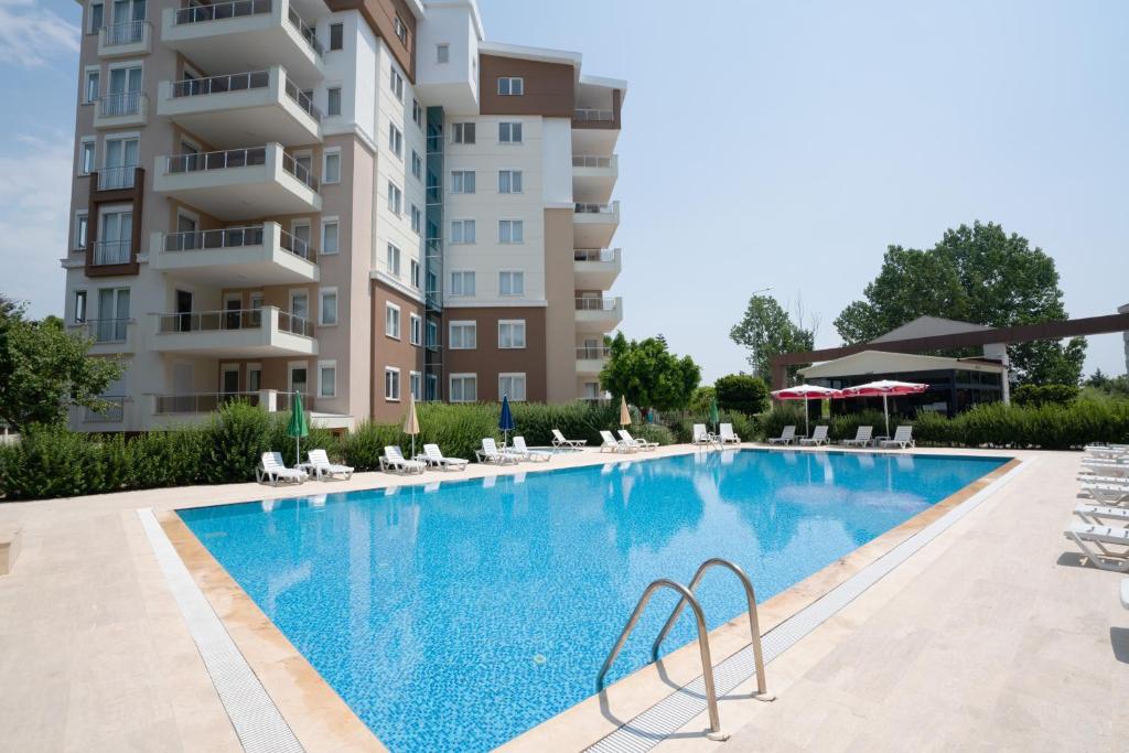 a swimming pool in front of a building at River Park Residence Lara in Antalya