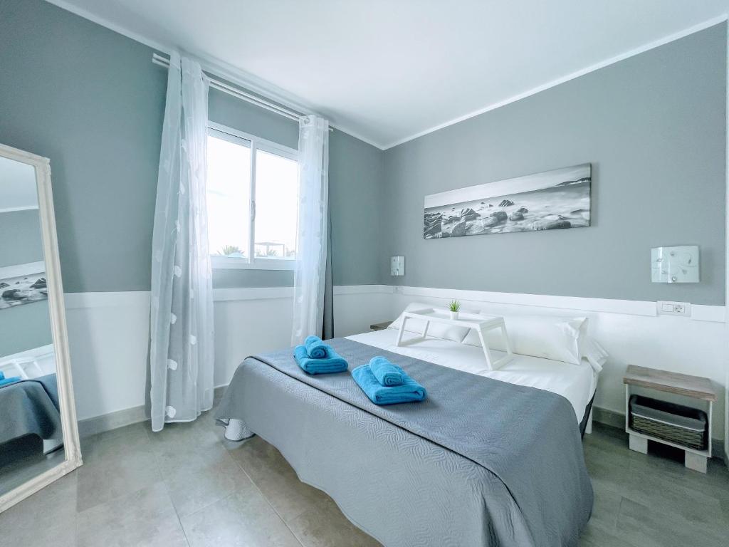 コラレホにあるAurora Corralejo iRent Fuerteventuraのベッドルーム1室(青いタオル付きのベッド1台付)