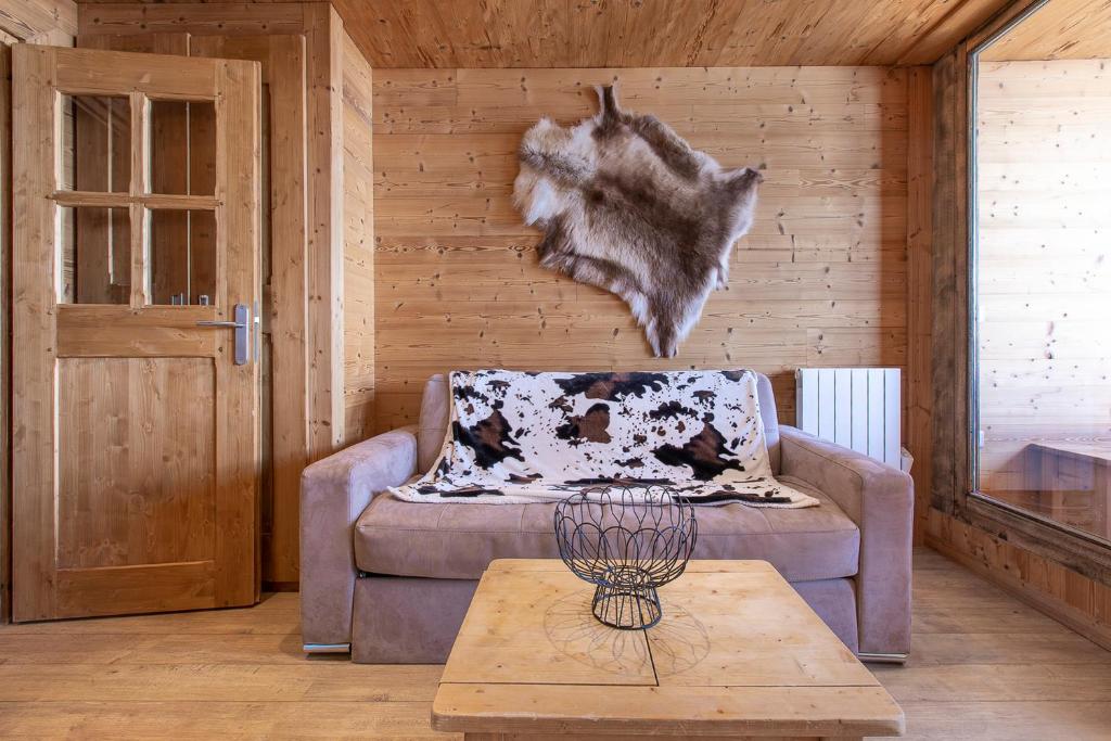 a living room with a couch and a wooden wall at Résidence Le Sérac - Val Thorens in Val Thorens