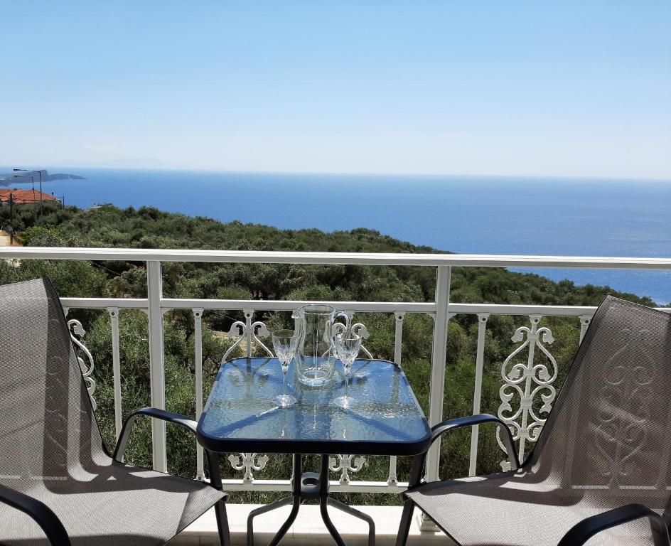 una mesa azul y sillas en un balcón con vistas al océano en Zoe's Studios, en Parga