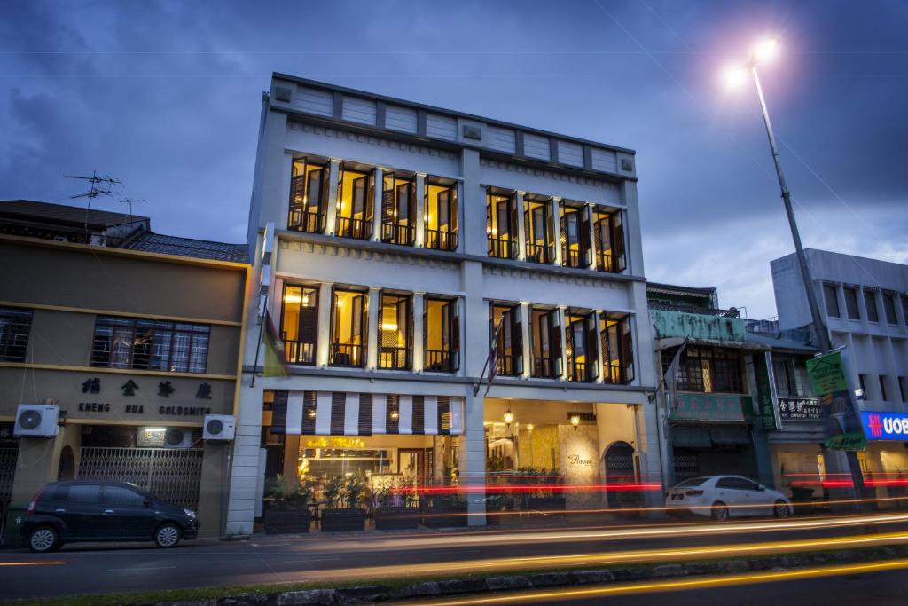 a building on a street with cars parked in front of it at The Ranee Boutique Suites in Kuching