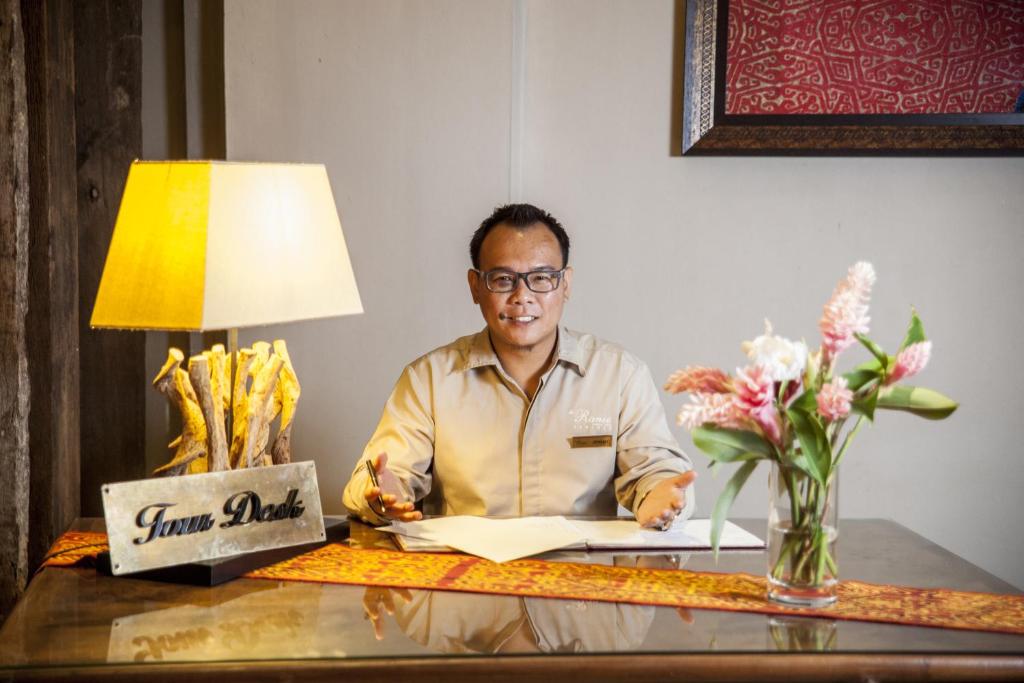 un uomo seduto a una scrivania con un documento di The Ranee Boutique Suites a Kuching