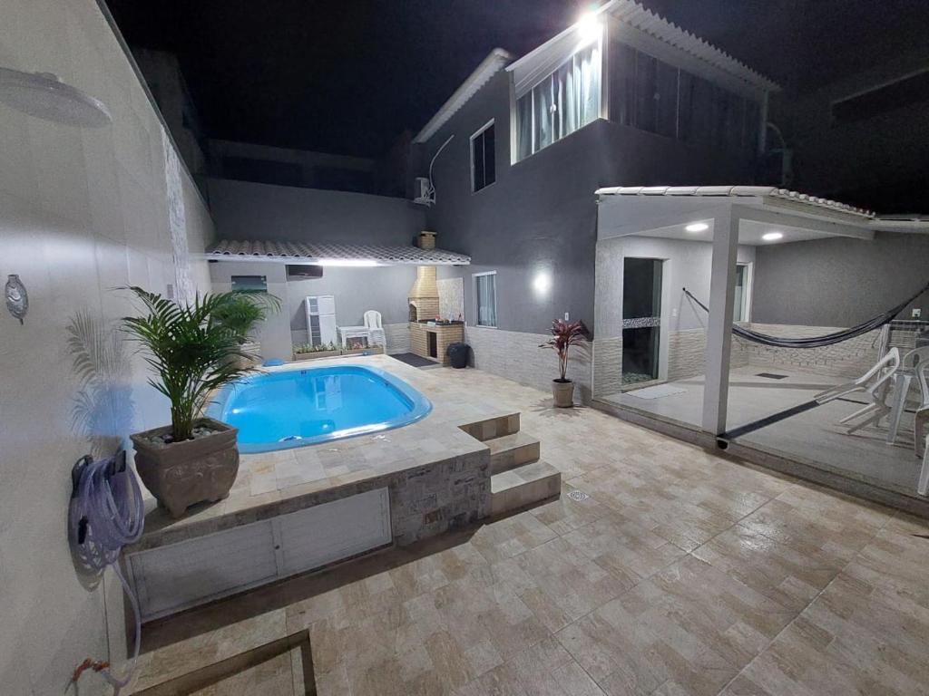 uma grande piscina com rede numa casa em Casa com piscina e churrasqueira em Cabo frio em Cabo Frio