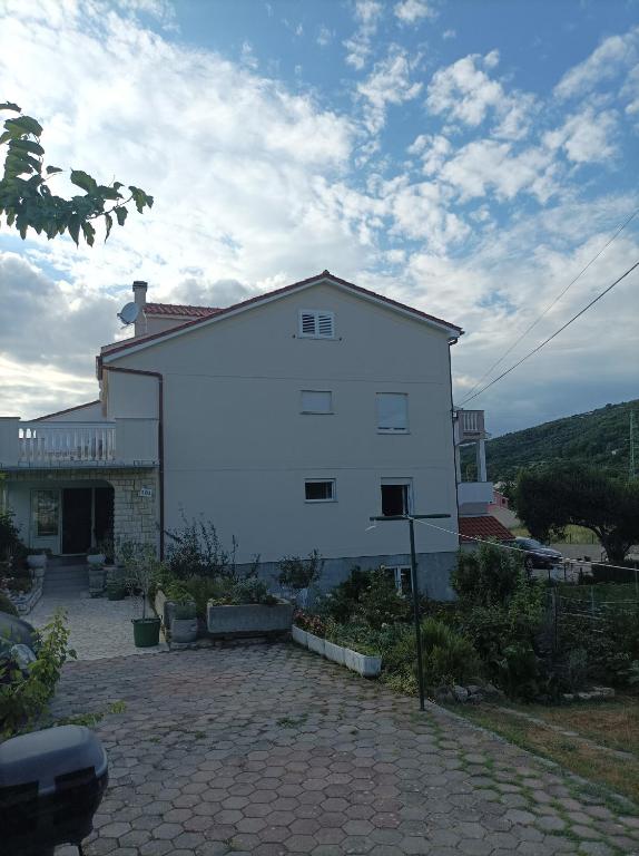 a large white house with a brick driveway at Feel Good Apartment Rab Mundanije 131 in Mundanije