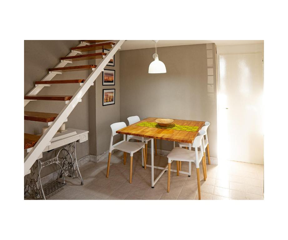 une salle à manger avec une table et un escalier dans l'établissement LAS ORQUIDEAS, à Plottier