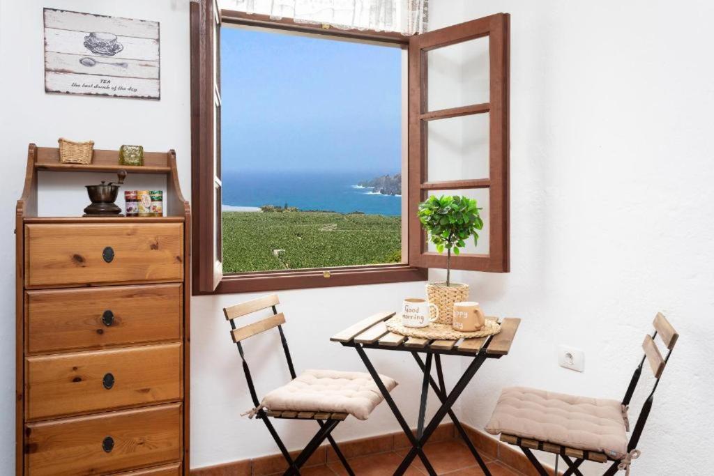 een tafel en 2 stoelen in een kamer met een raam bij CASA CANARIA ACERÓ in Garachico