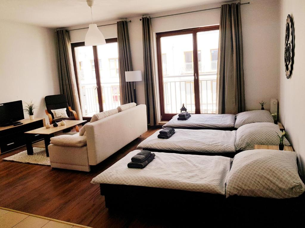 salon z dwoma łóżkami i kanapą w obiekcie Apt with 6 single beds w Świnoujściu
