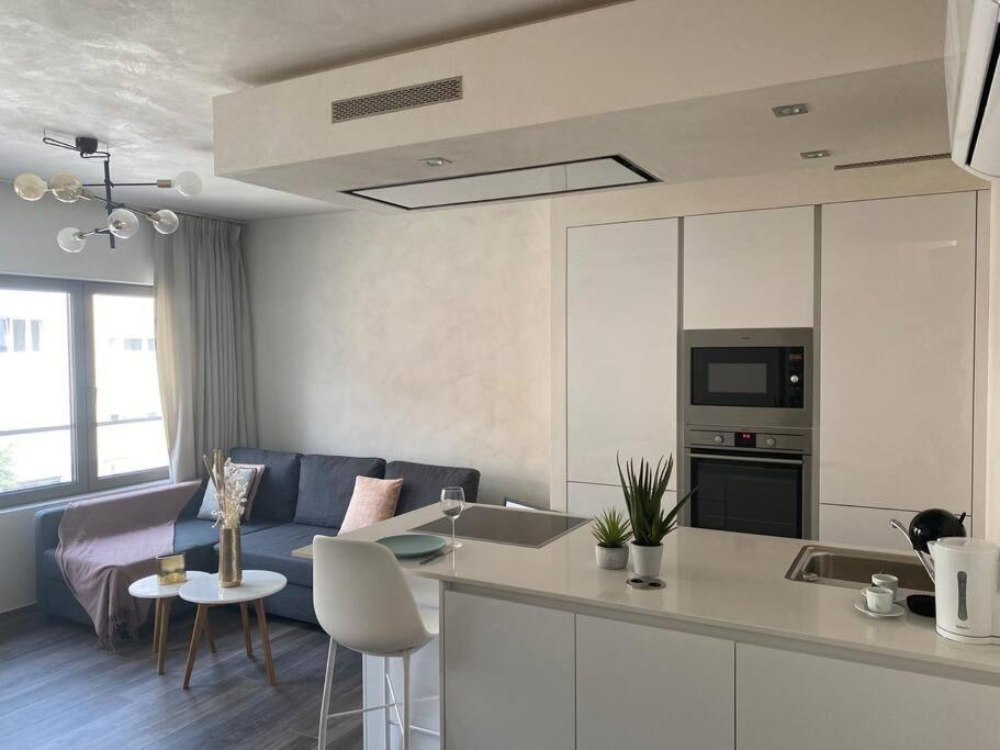 een keuken en een woonkamer met een bank en een tafel bij Lovely One Bedroom Apartment in City Center with Parking, near Public Transport in Luxemburg