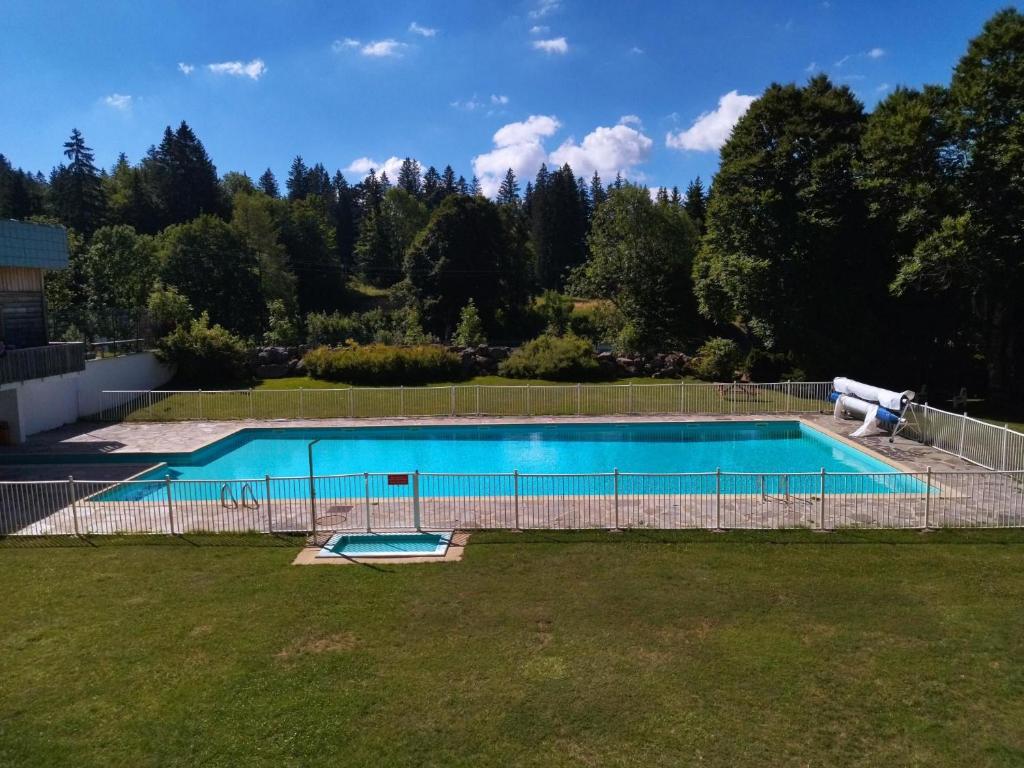 uma piscina vazia com uma cerca à volta em Studio Le Lacuzon avec piscine et tennis extérieurs em Les Rousses