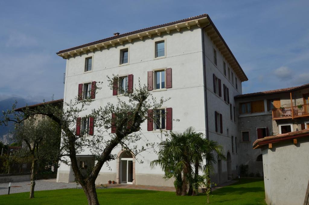 un edificio blanco con un árbol delante en Palazzo Oltre, en Arco