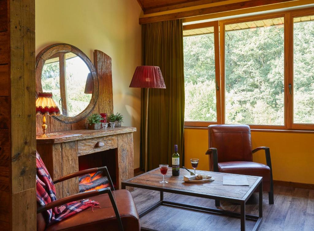 - un salon avec une table et une cheminée dans l'établissement Droom Suite Cetturu - Luxe 2 pers suite bij leuke herberg, à Houffalize