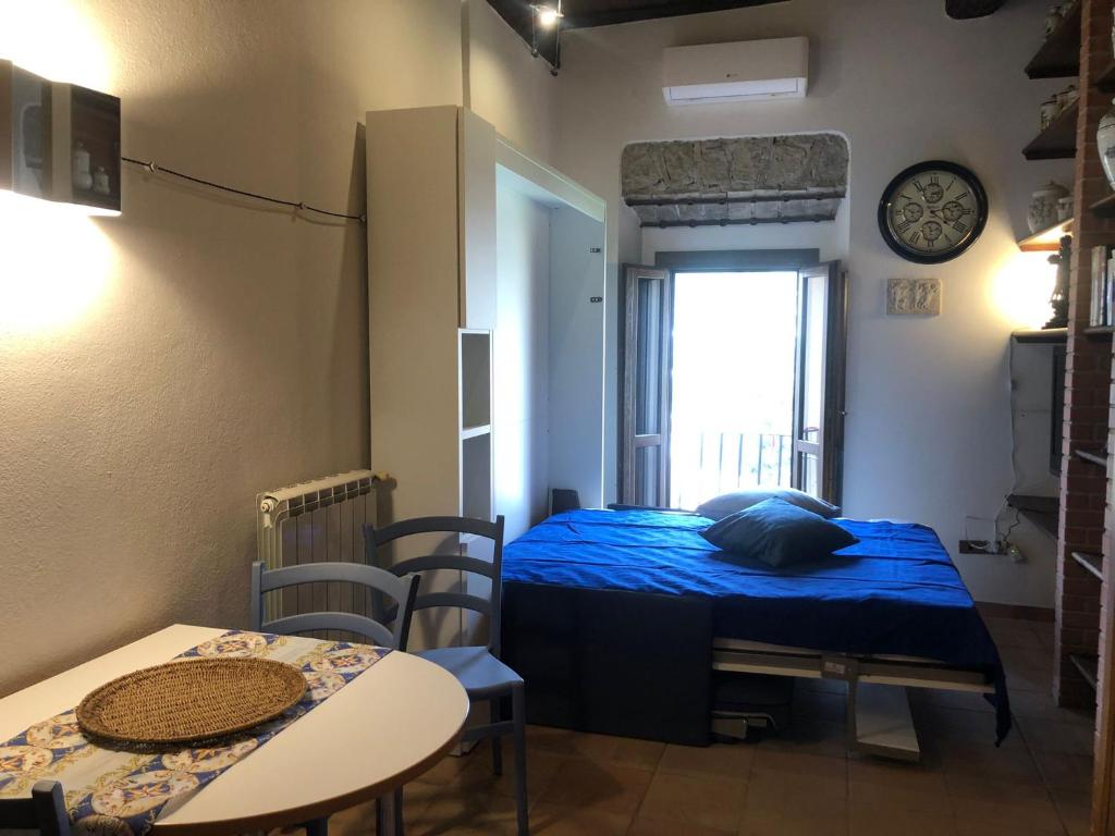 um pequeno quarto com uma cama, uma mesa e cadeiras em La Casina di Tonia em Terracina