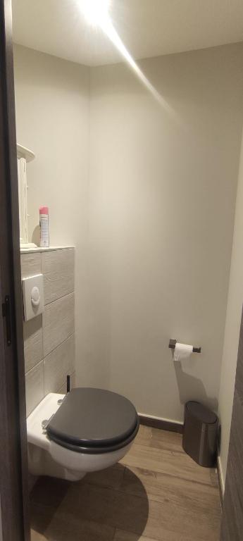 a bathroom with a toilet with a black lid at Le Rouveau in Six-Fours-les-Plages