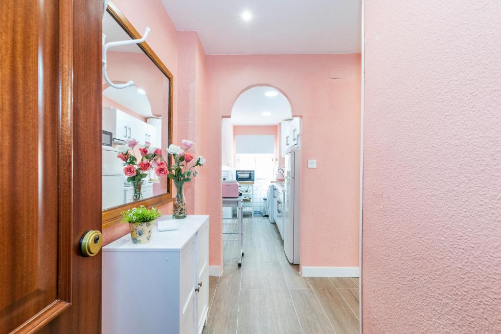 un baño con paredes rosas y un mostrador con flores. en Precioso Apartamento en el Centro de Granada, en Granada