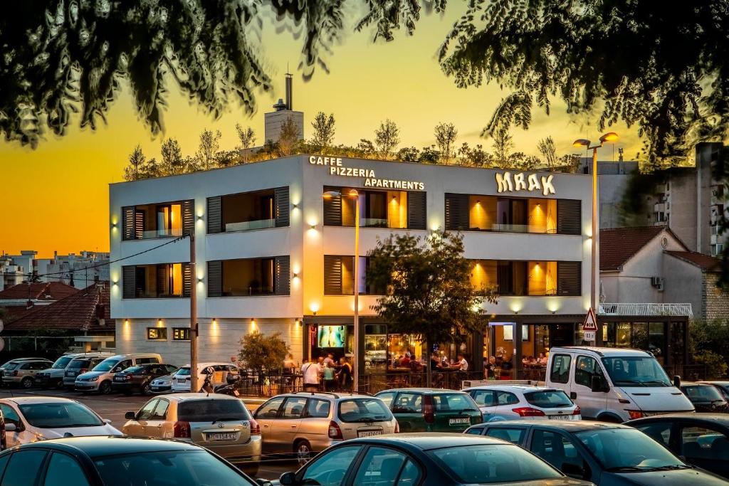 a building with cars parked in a parking lot at Mrak Zadar Exclusive in Zadar