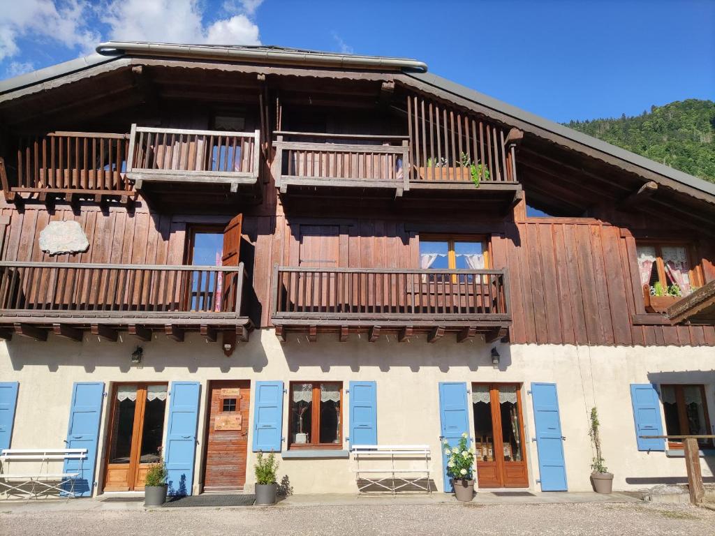 uma casa de madeira com varandas e janelas em La Ferme d'Henriette, à Samoëns em Samoëns