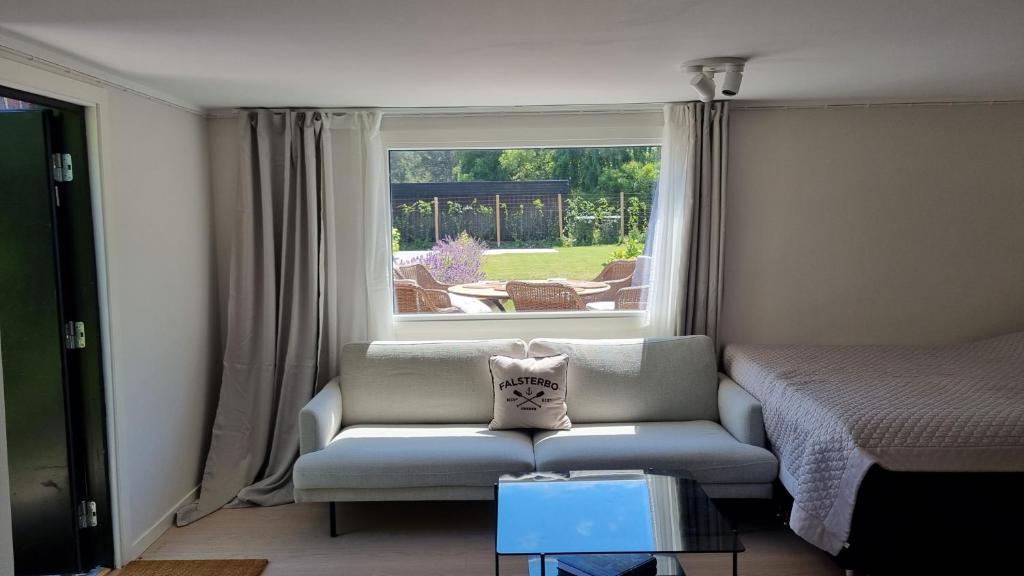 sala de estar con sofá y ventana en Falsterbo Guesthouse - Modern & Comfy, en Skanör med Falsterbo