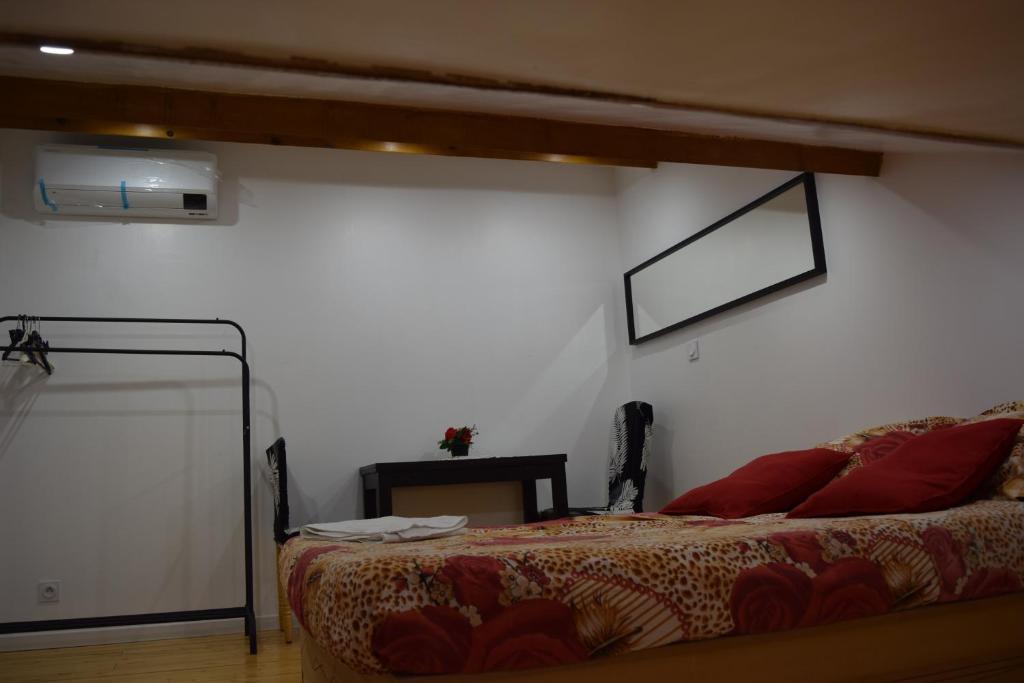 a bedroom with a bed and a white wall at Appartement La Paix in Pibrac
