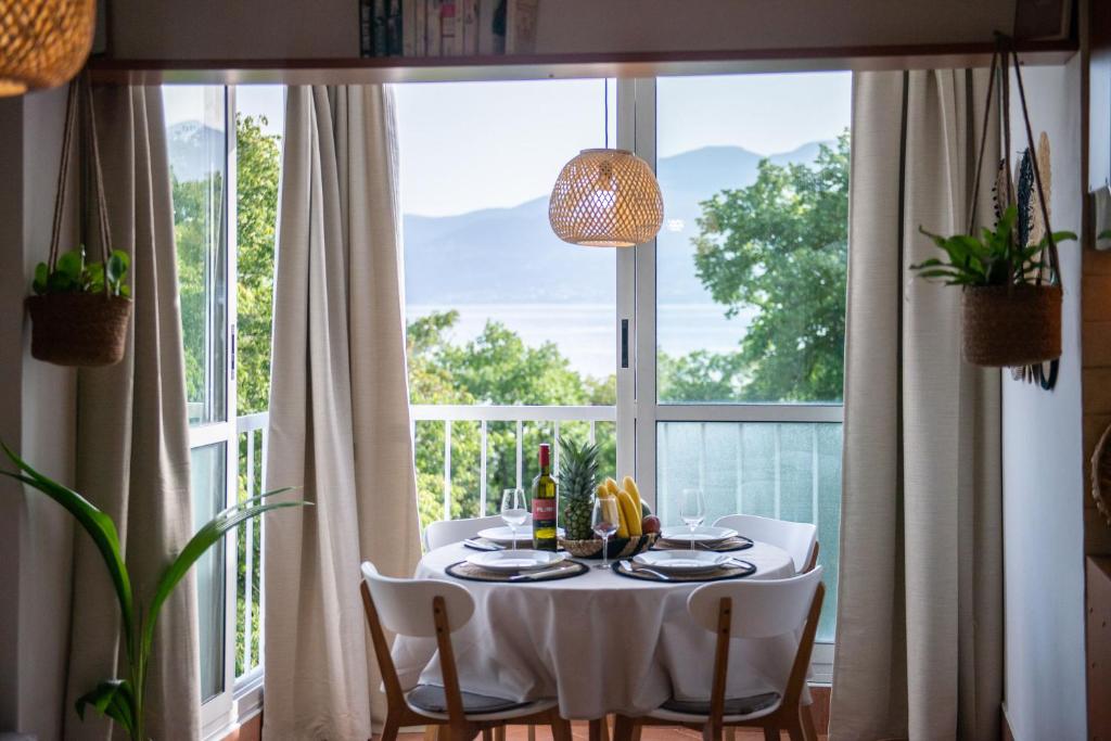 a dining room table with a white table cloth and a window at Cosy private boho app Nook in Rijeka near Opatija in Rijeka