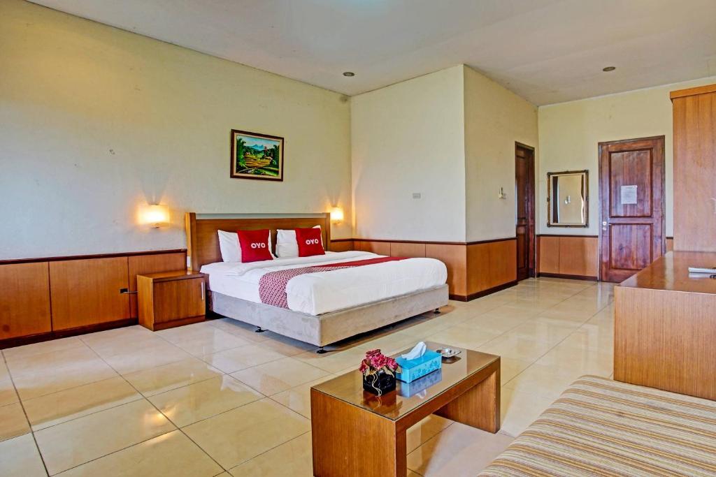 a hotel room with a bed and a couch at OYO 90947 Hotel Sarbini in Menggala