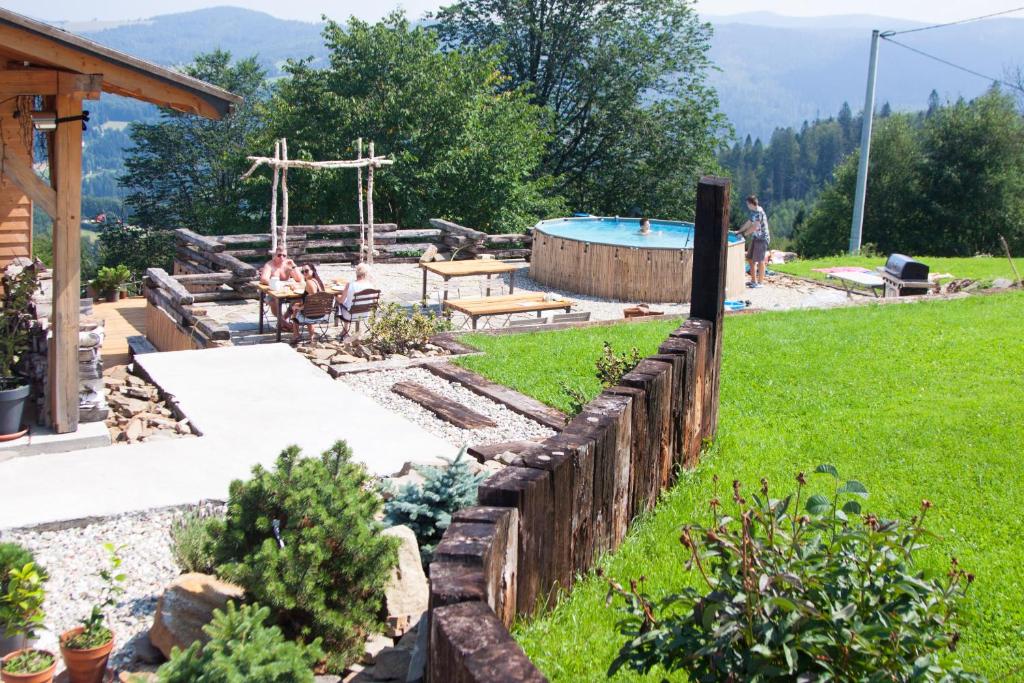 een achtertuin met een zwembad en een houten hek bij Swoboda na szczycie góry in Brenna